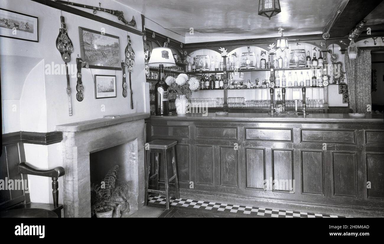 Années 1950, bar de pub historique et vide à l'Angel Inn, Witney, Oxford,  Angleterre, Royaume-Uni montrant un comptoir de bar traditionnel avec  pompes à main, optique, tabouret et articles décoratifs au-dessus de