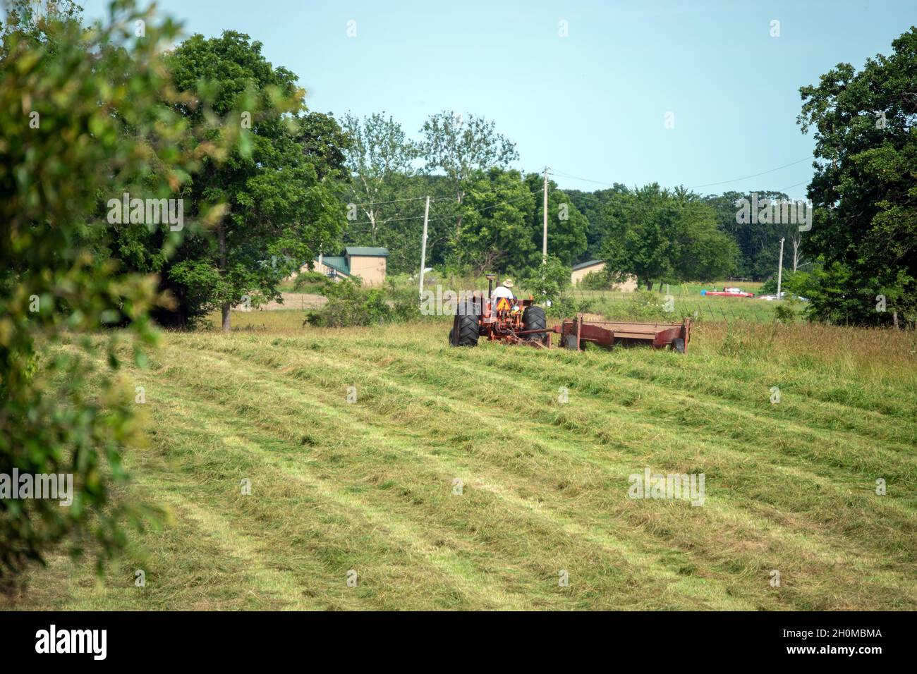 Il est temps de faire le foin.C'est l'été et c'est sec et c'est le moment idéal pour les agriculteurs de monter sur leurs tracteurs et de commencer la préparation de la mise en balles de foin Banque D'Images