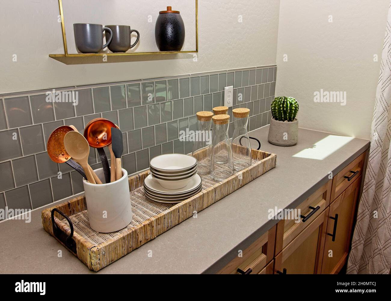 Panier de cuisine en osier avec ustensiles, vaisselle et décanteurs en verre Banque D'Images