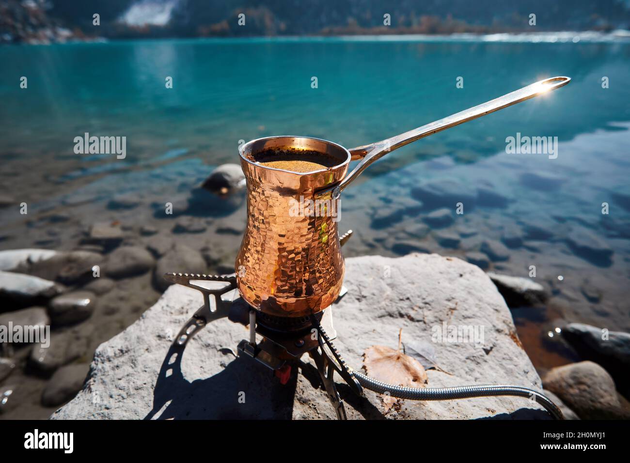 Cuivre Cézve pour le café en automne camping lac dans les montagnes.Préparation du café sur cuisinière à gaz concept de camping extérieur Banque D'Images