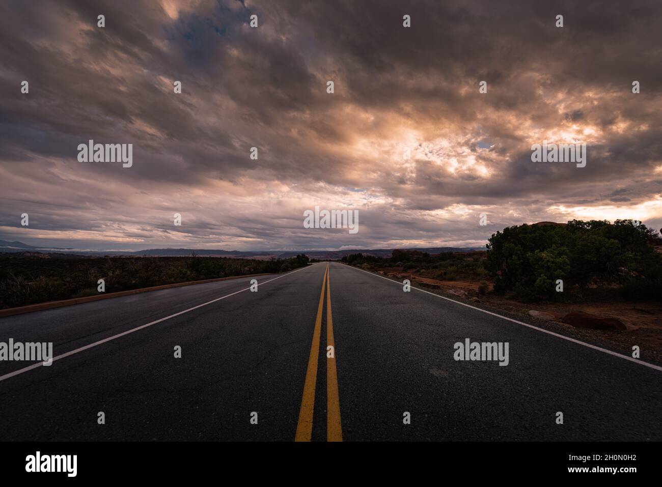 Longue route désertique au milieu de nulle part sous un ciel nuageux et sombre et spectaculaire Banque D'Images