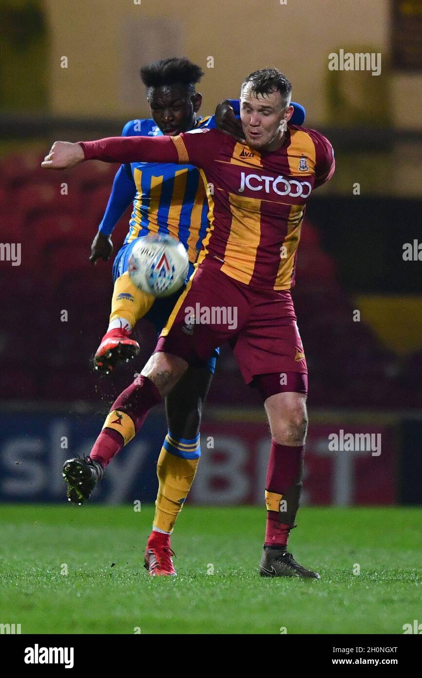 Charlie Wyke de Bradford City et Aristote Nsiala de Shrewsbury Town se battent pour le ballon Banque D'Images