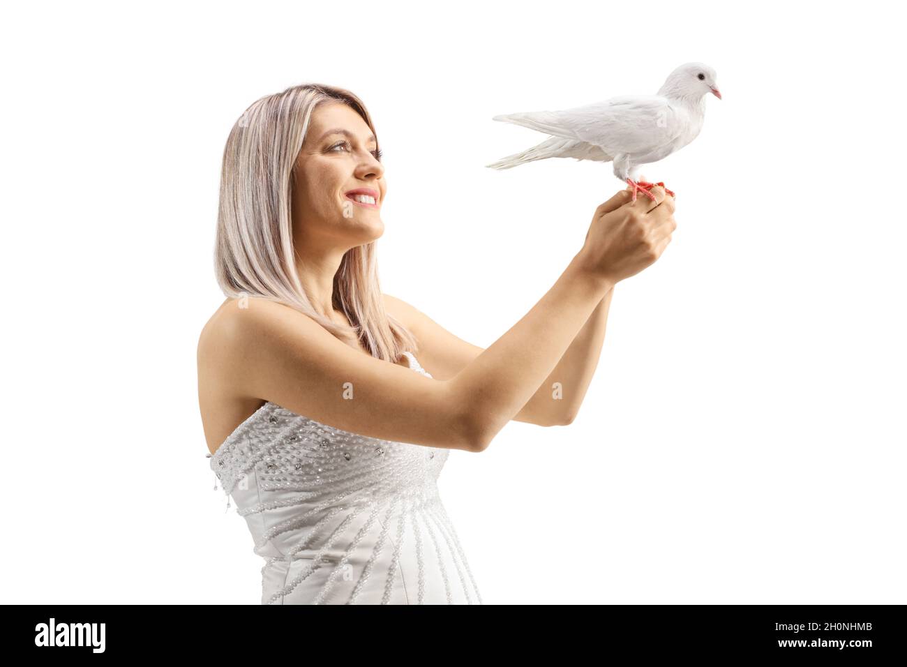 Belle mariée tenant une colombe blanche et souriante isolée sur fond blanc Banque D'Images