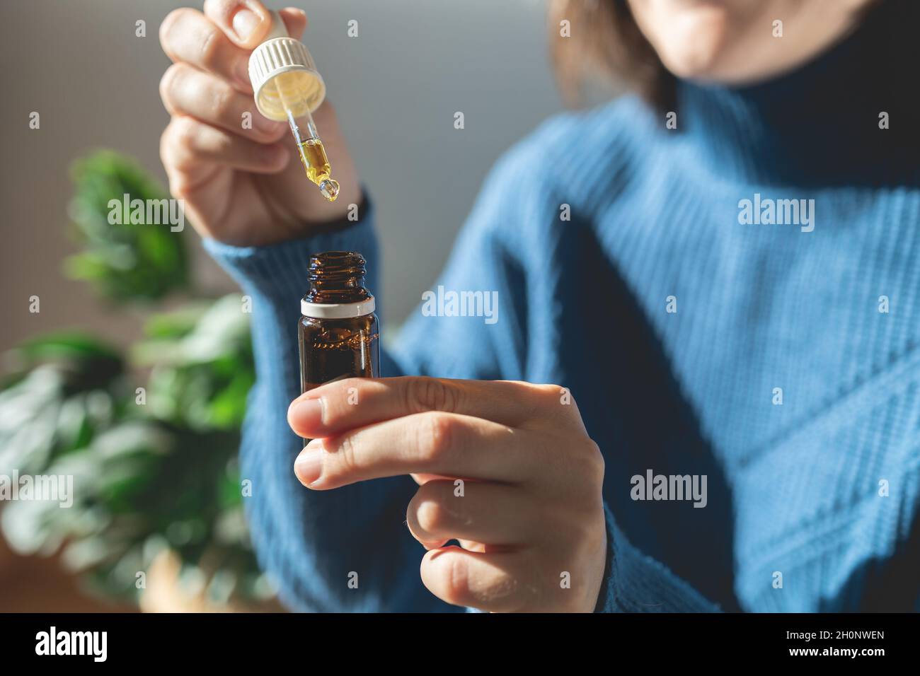 Thérapie alternative au CBD - femme tenant une bouteille d'huile de cannabis pour le traitement de l'anxiété Banque D'Images