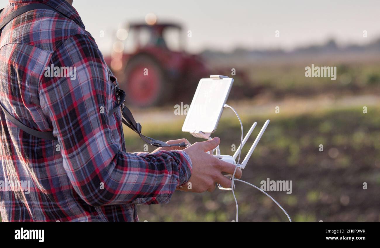 Gros plan de la télécommande avec une tablette pour drone dans les mains des agriculteurs sur le terrain.Innovations de haute technologie pour accroître la productivité dans l'agriculture Banque D'Images