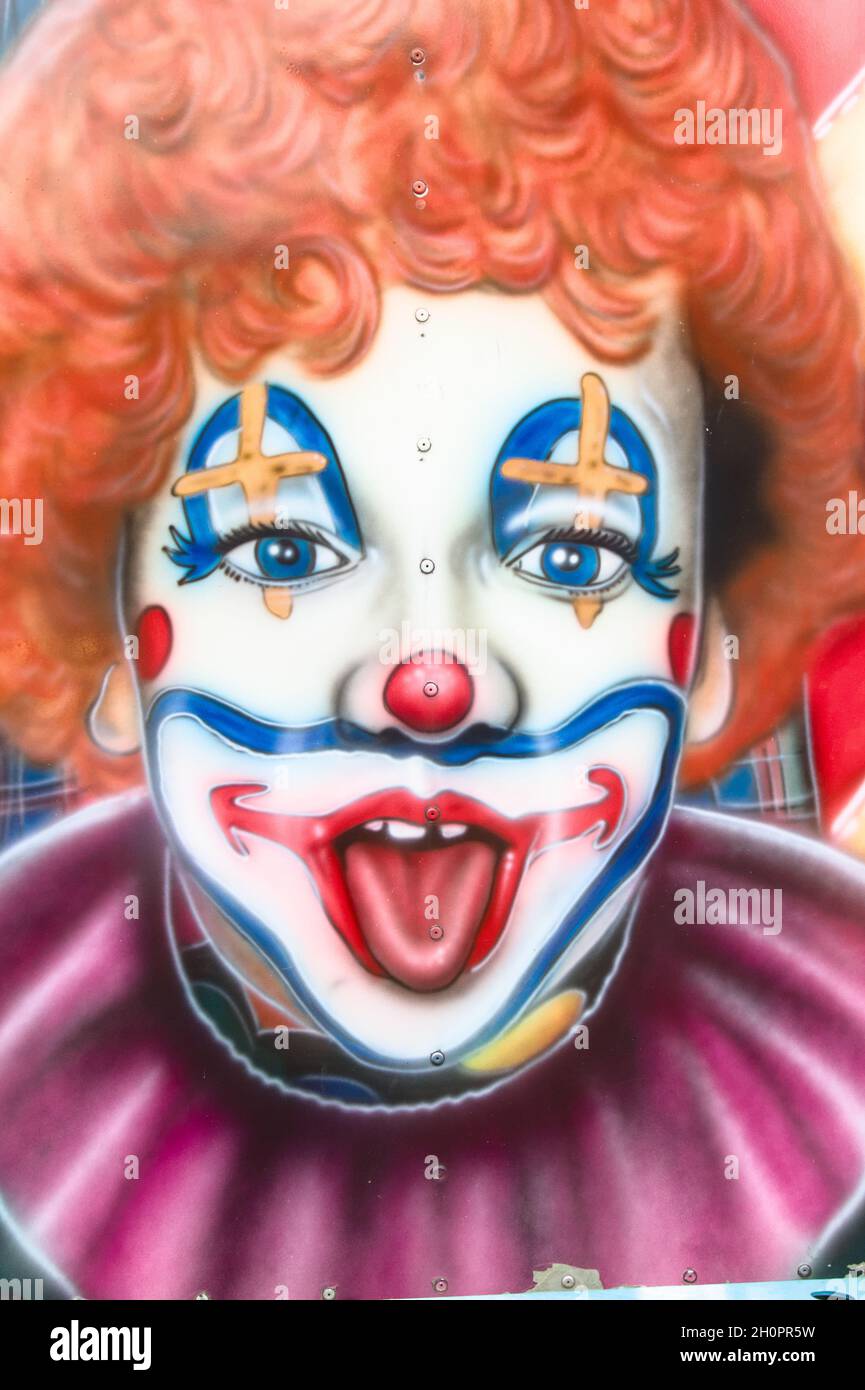 Peinture aérographe d'Un clown riant avec des cheveux Orange dans Un Funfair Royaume-Uni Banque D'Images