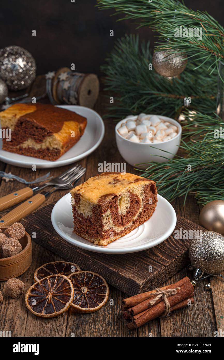 Un morceau de gâteau sur un fond festif avec des branches de pin. Banque D'Images