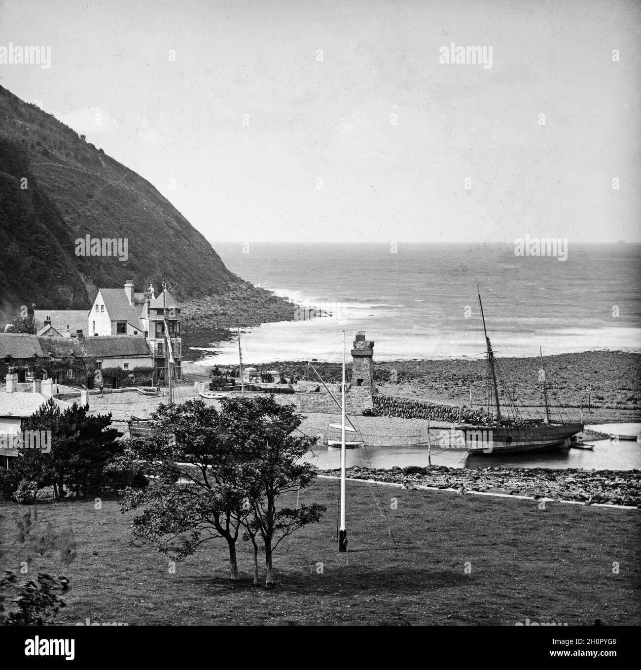 Photographie vintage en noir et blanc de la fin de l'époque victorienne montrant le port de Lynmouth à Devon, en Angleterre.On y trouve la tour Rhenish ainsi que des bateaux à voile de l'époque. Banque D'Images