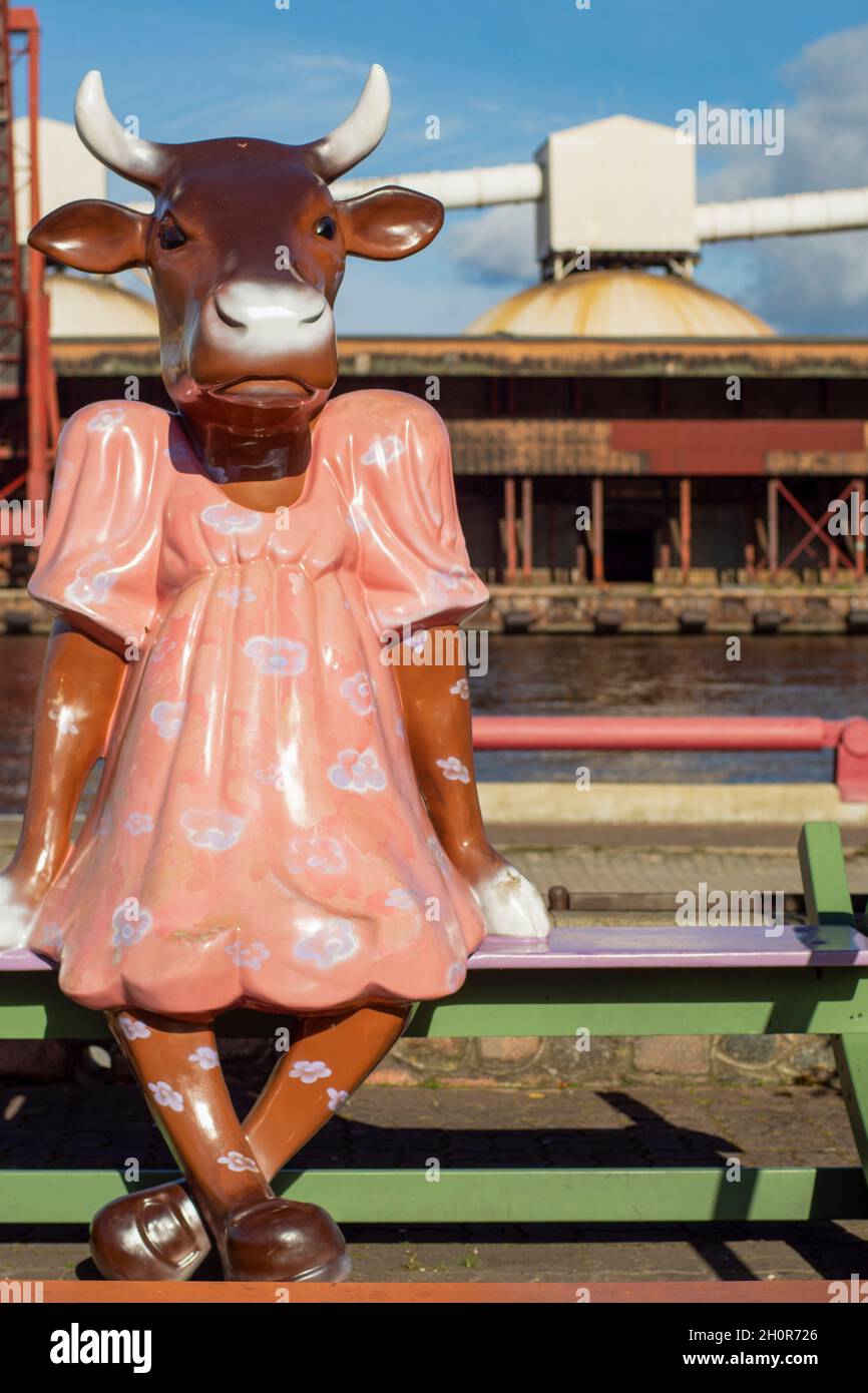 Une statue de vache girly qui a quitté après la parade de la vache (l'un des plus grands événements d'art public) sculpture à Ventspils.La jolie vache à bascule en robe rose. Banque D'Images