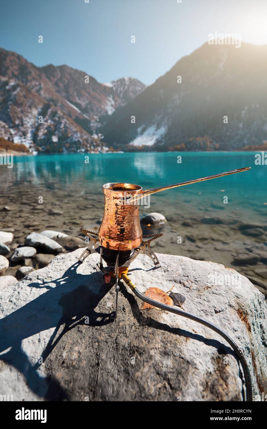 Cuivre Cézve avec café sur un poêle à gaz en automne camping lac dans les montagnes.Préparation du café concept extérieur Banque D'Images