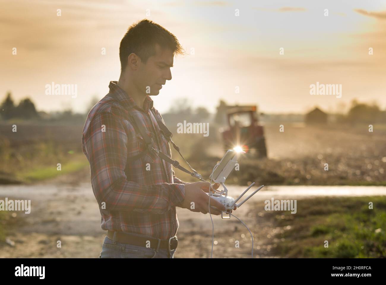 Un agriculteur séduisant naviguant au-dessus des terres agricoles.Innovations de haute technologie pour accroître la productivité dans l'agriculture Banque D'Images