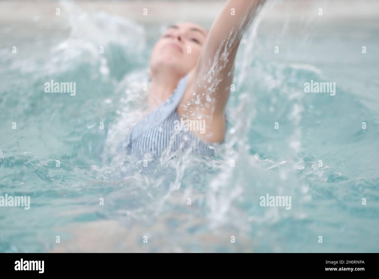 Gros plan d'une femme qui nage en contre-courant dans une piscine Banque D'Images