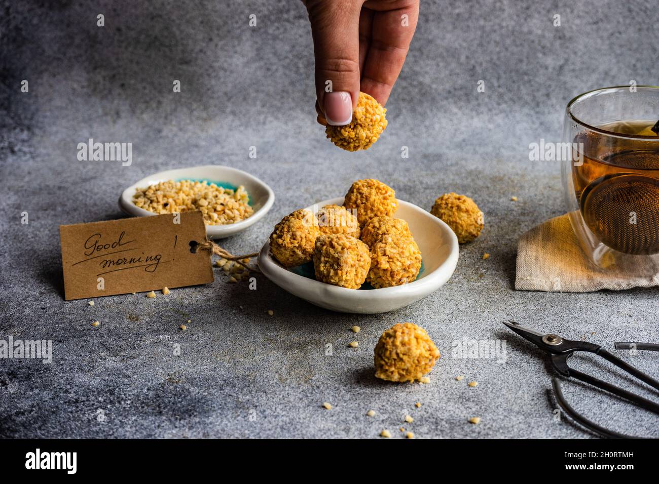 Femme appréciant des boules de bonbons saines faites maison avec du thé Banque D'Images