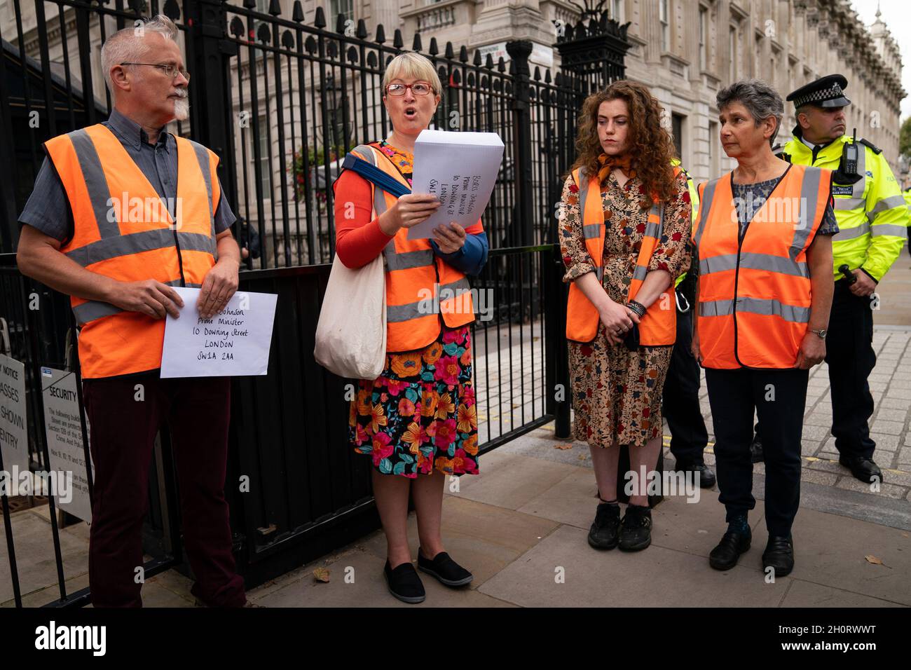 Un membre d’Isolate Britain lit une lettre au Premier ministre Boris Johnson avant d’essayer de la remettre au 10 Downing Street, Londres.Le groupe climatique, qui a causé de la misère aux conducteurs avec des manifestants assis sur l'autoroute M25 et d'autres routes principales, a déclaré qu'il va arrêter sa "campagne de résistance civile" jusqu'en octobre 25.Date de la photo: Jeudi 14 octobre 2021. Banque D'Images