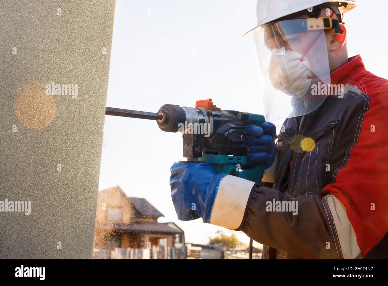 Un installateur mâle travaille avec un marteau perforateur.Travaux de construction Banque D'Images