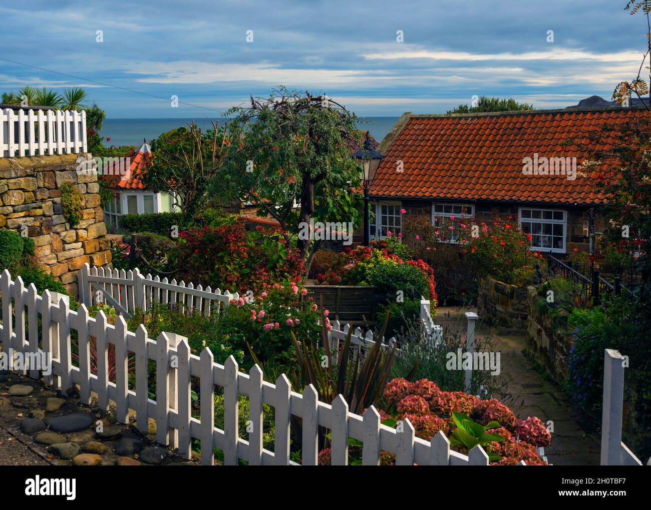 Au début de l'automne, les petits jardins du village de Runswick sont bien entretenus et colorés Banque D'Images