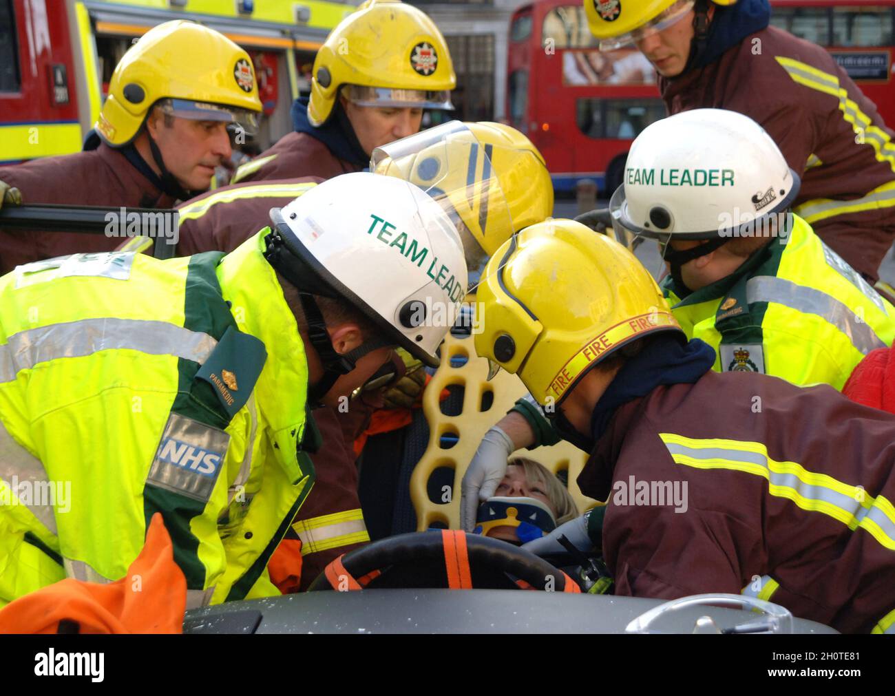 Les équipes d'incendie et d'ambulance travaillent à libérer un passager piégé dans un véhicule à la suite d'une collision Banque D'Images