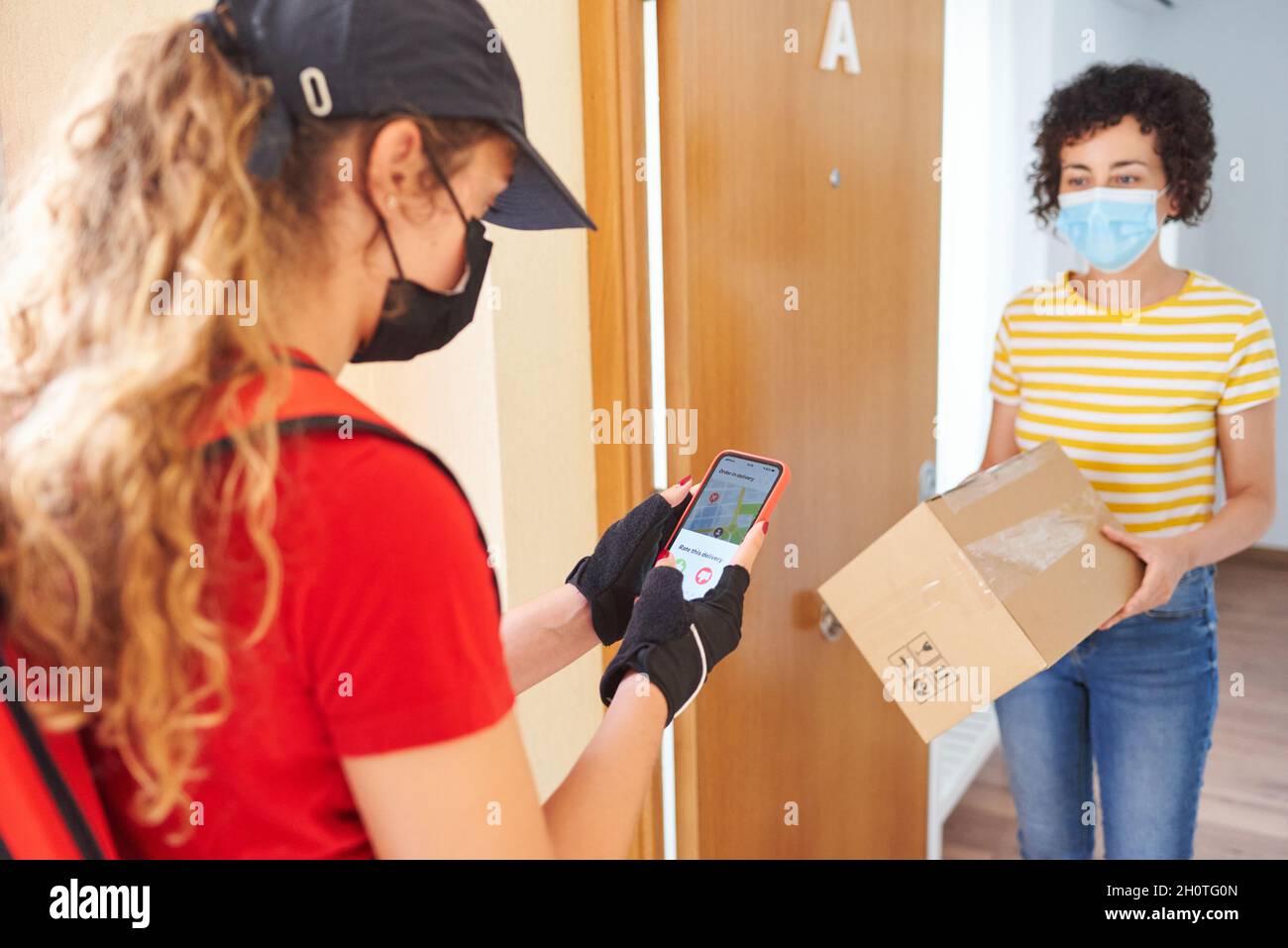 Femme qui a livré l'appareil à l'aide d'un téléphone portable pour confirmer la livraison Banque D'Images