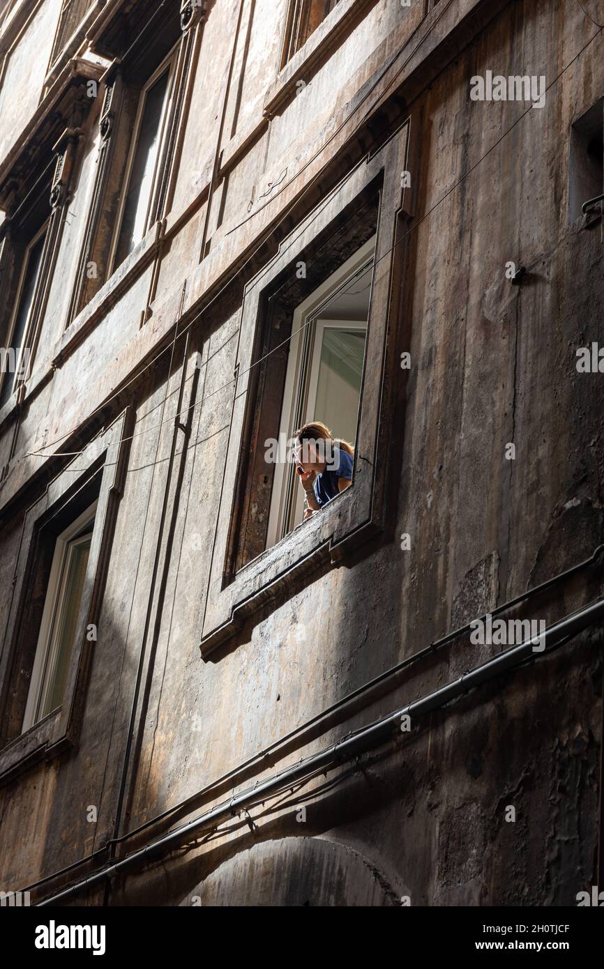 Une femme au téléphone s'est penchée de la fenêtre à Rome, en Italie Banque D'Images