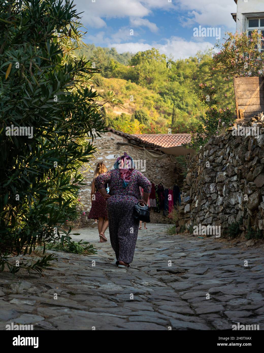 Siroce Village, Izmir, Turquie - août 23 20121 : vue arrière des femmes marcher sur la route en pierre à Siroce célèbre pour les maisons traditionnelles de village. Banque D'Images