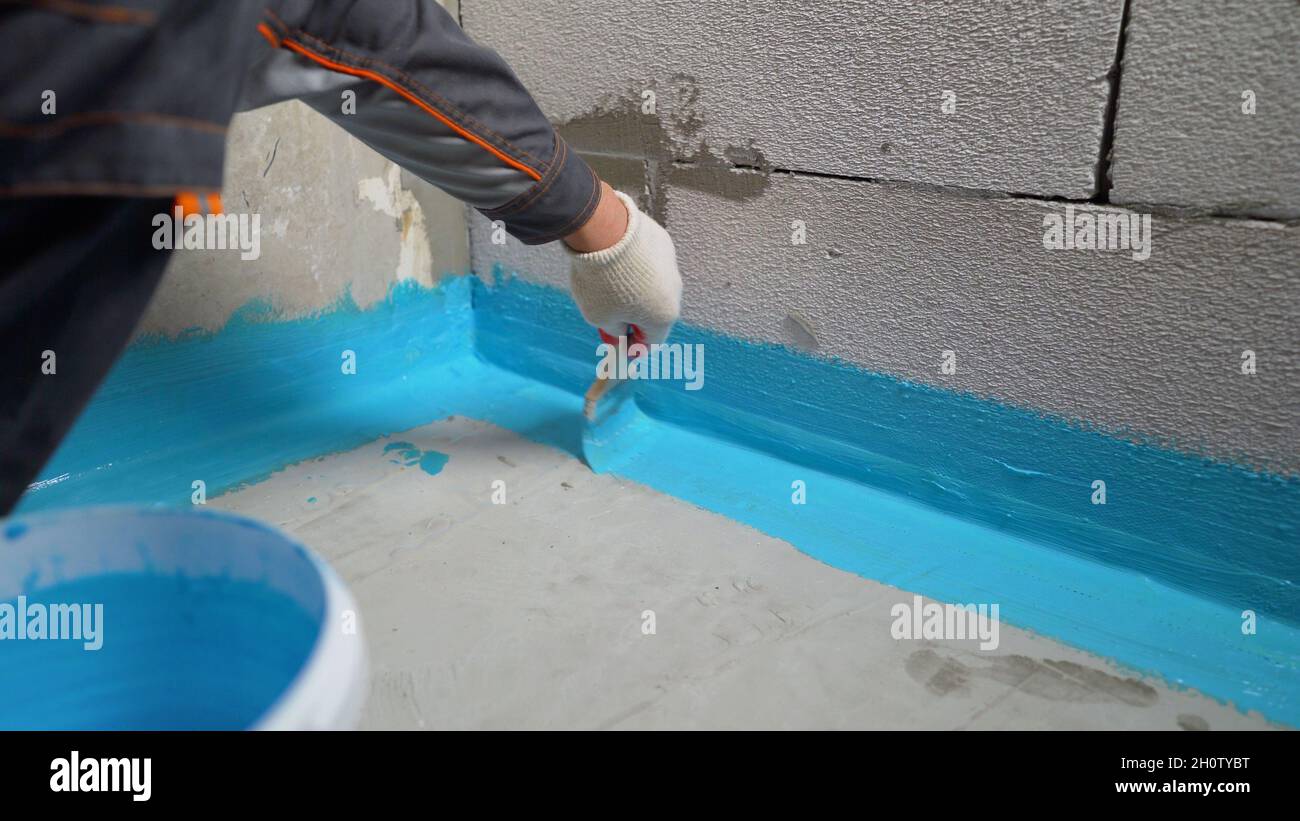 Le revêtement imperméable est bleu.Couvrir le mur en béton d'une membrane  imperméable en polymère de ciment.Imperméabilisation à l'aide d'une brosse  bleue Photo Stock - Alamy