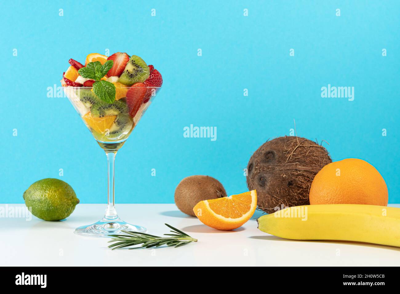 Cocktail de fruits en verre martini sur fond lumineux. Concept végétalien alimentaire minimal. Banque D'Images