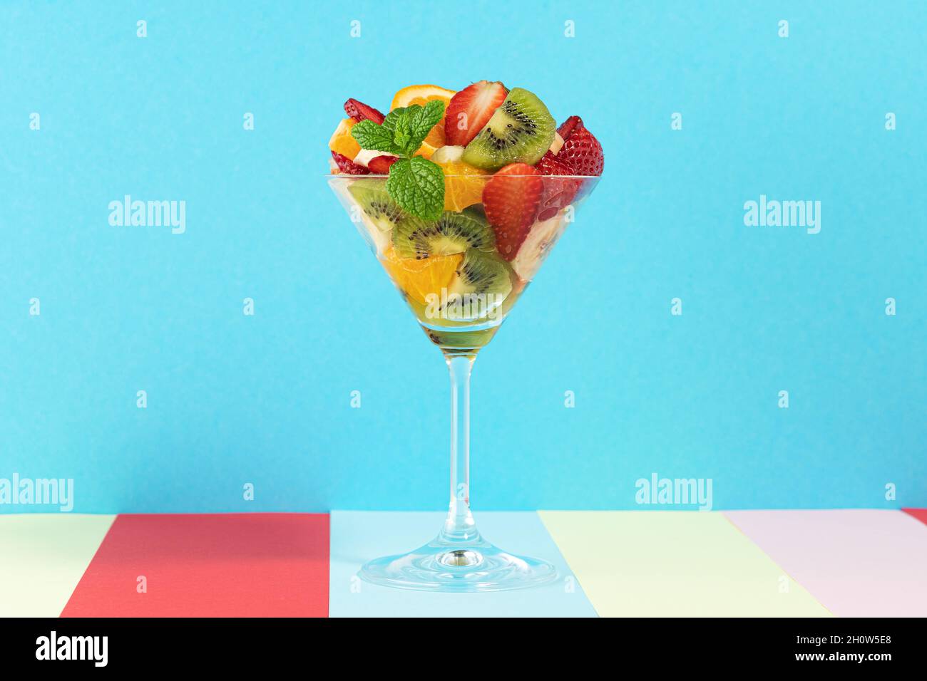 Cocktail de fruits en verre martini sur fond lumineux. Concept végétalien alimentaire minimal. Banque D'Images