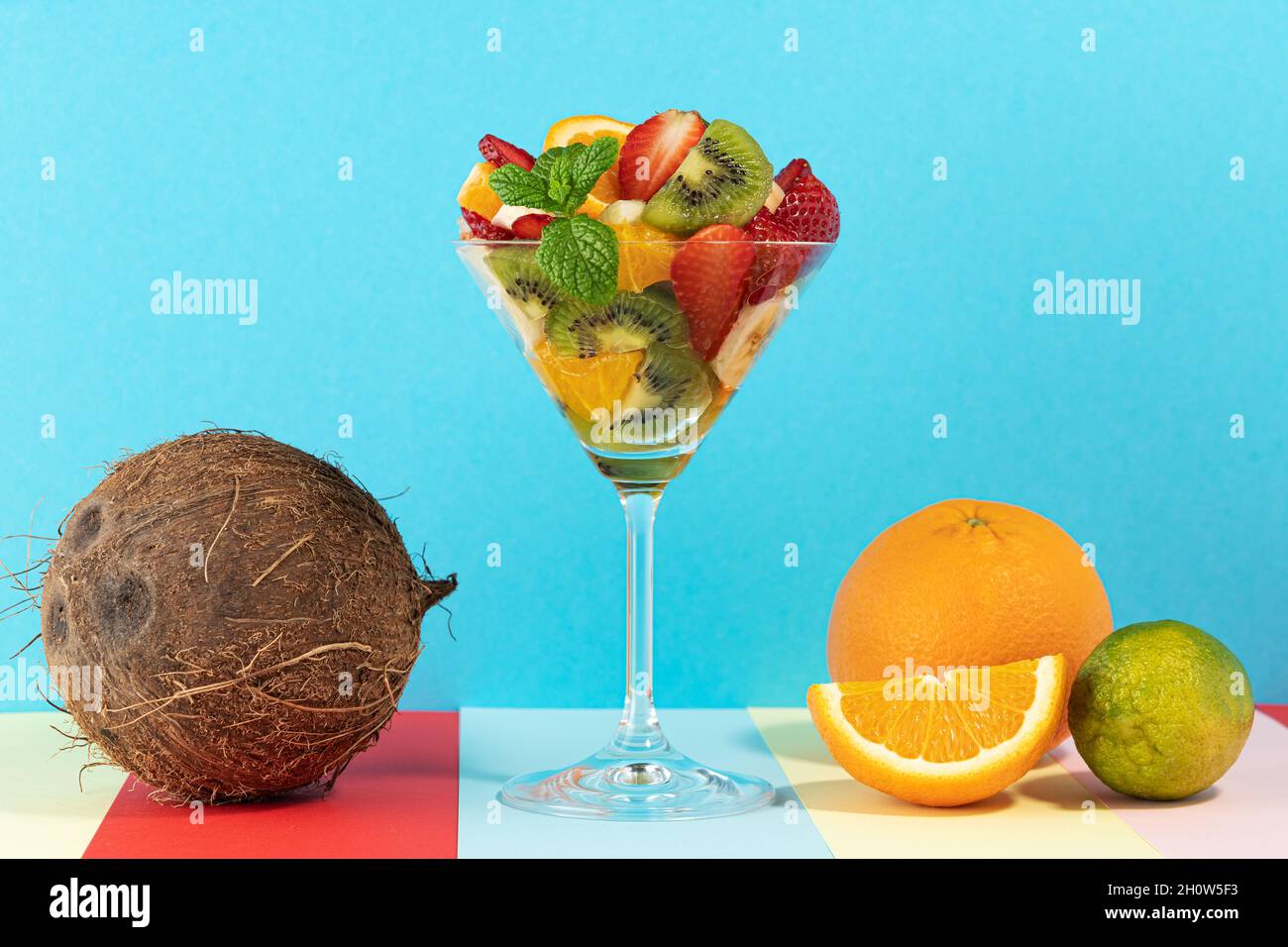 Cocktail de fruits en verre martini sur fond lumineux. Concept végétalien alimentaire minimal. Banque D'Images