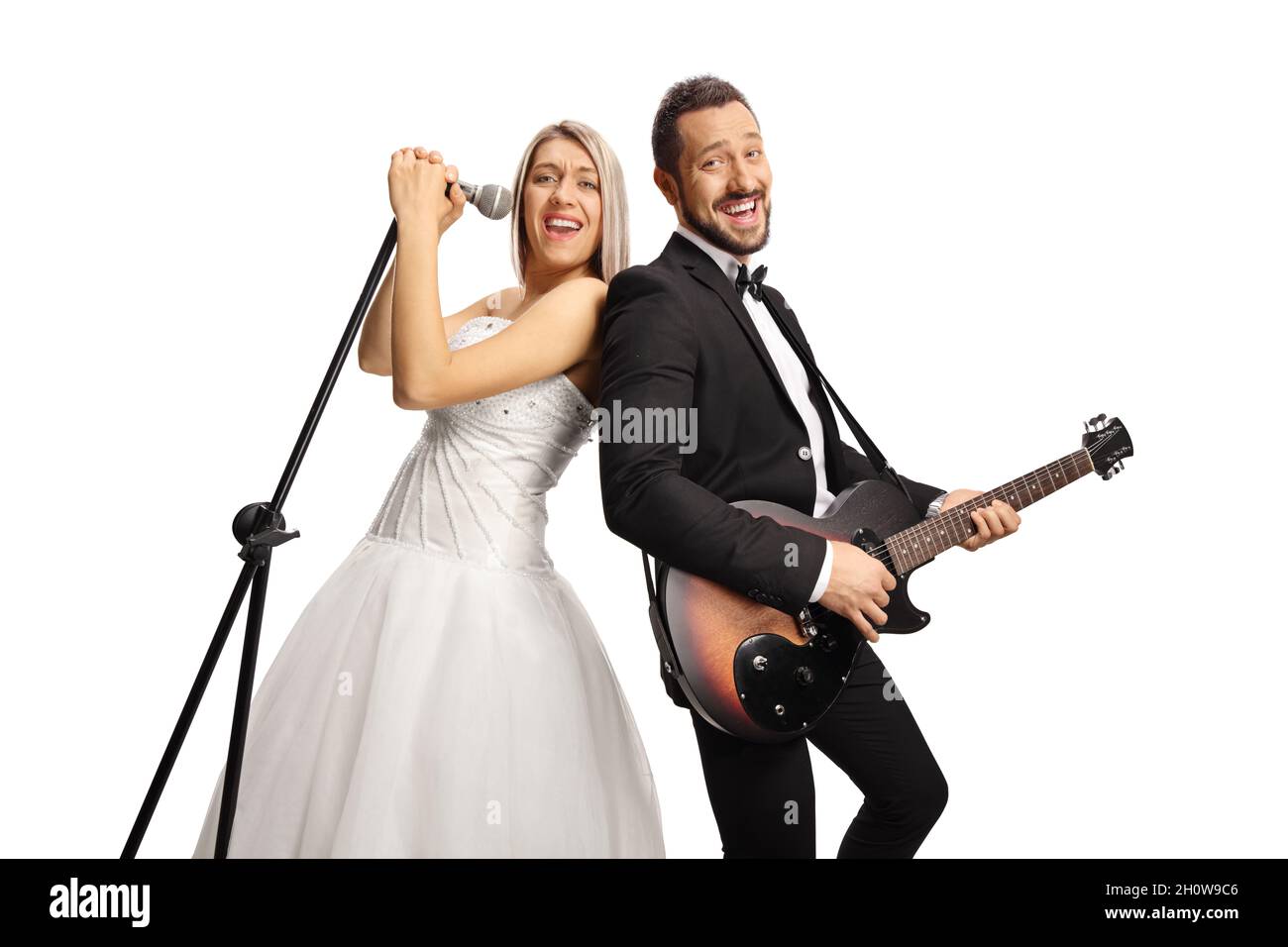 Mariée et marié gaie avec une guitare et un microphone chantant et souriant isolés sur fond blanc Banque D'Images