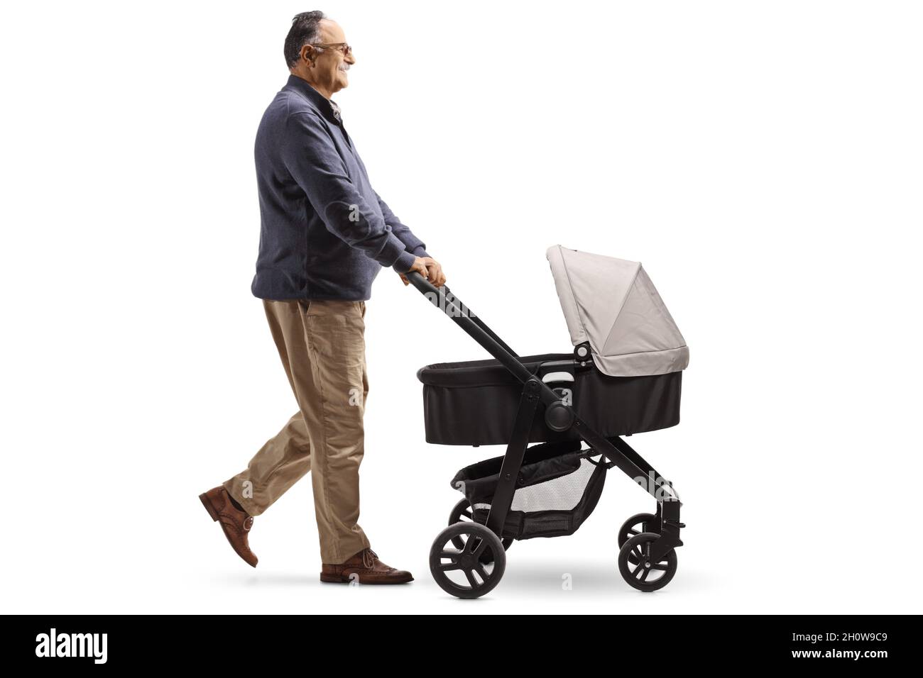 Photo de profil d'un homme mûr marchant avec une poussette de bébé isolée sur fond blanc Banque D'Images