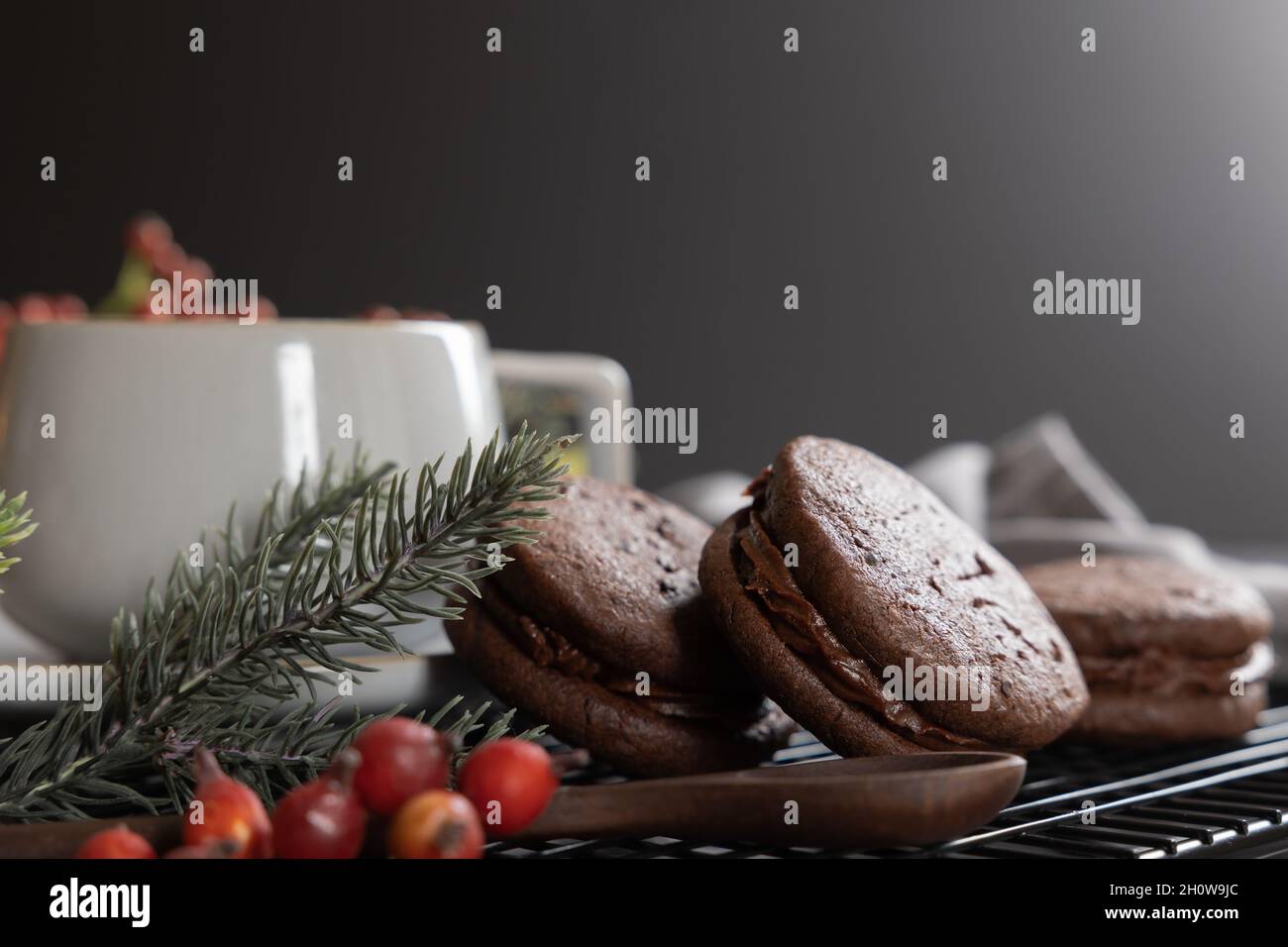 Gâteau de Noël de biscuits sandwich au café et au chocolat avec bordure de baies de noël et de quartiers à feuilles persistantes Banque D'Images