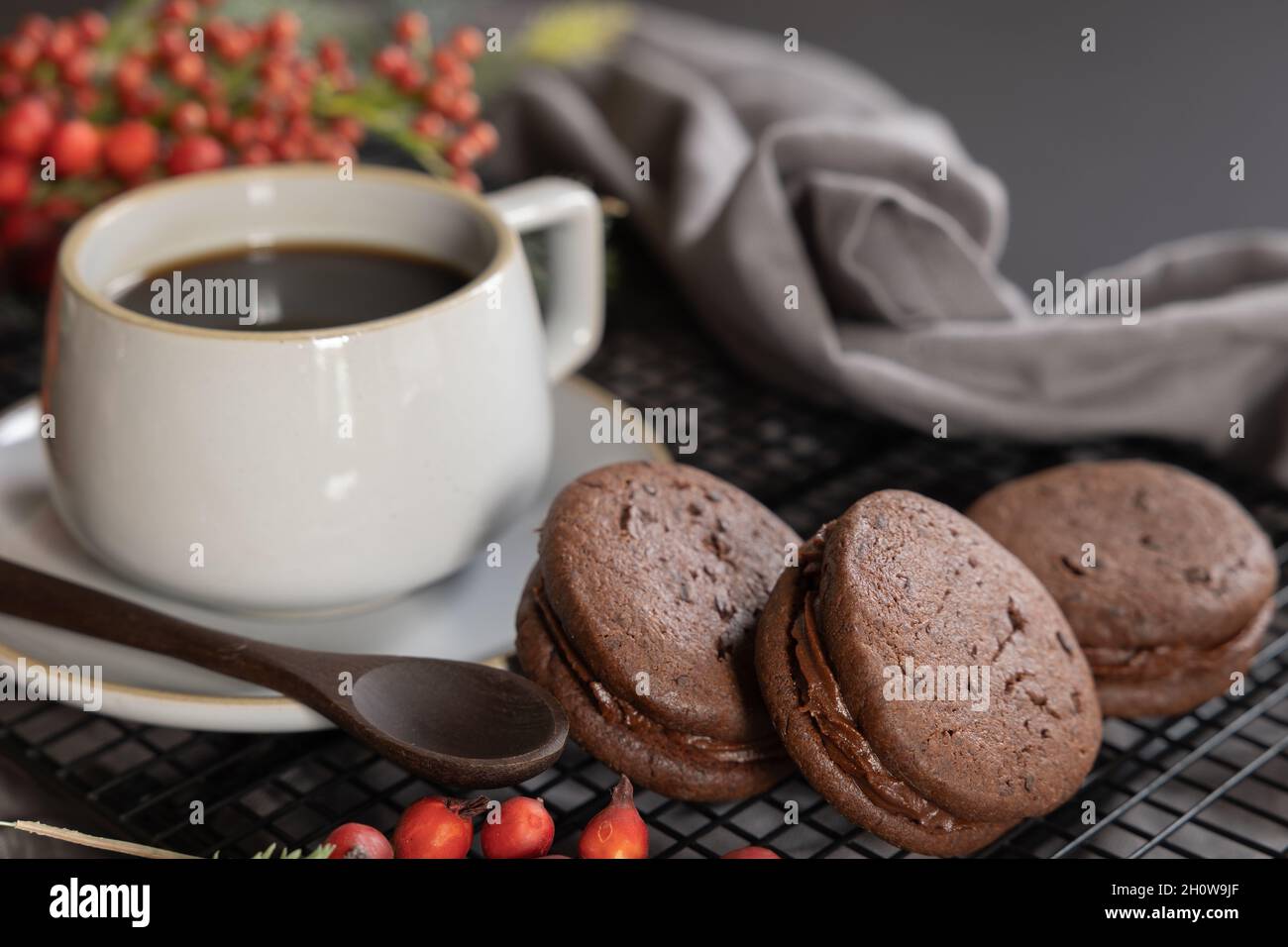 Gâteau de Noël de biscuits sandwich au café et au chocolat avec bordure de baies de noël et de quartiers à feuilles persistantes Banque D'Images