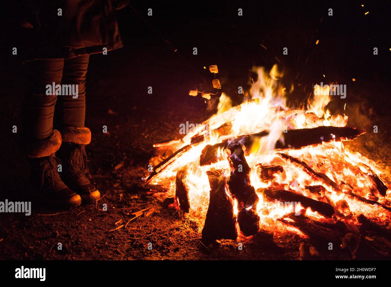 femme debout près de la fosse de feu extérieure la nuit Banque D'Images