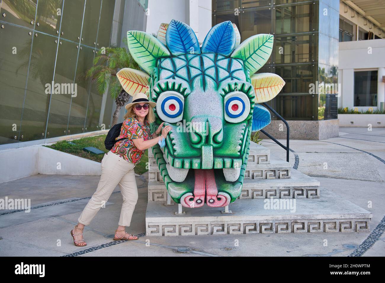 Femme touriste poussant une sculpture à Cancun, Mexique, 2021 Banque D'Images
