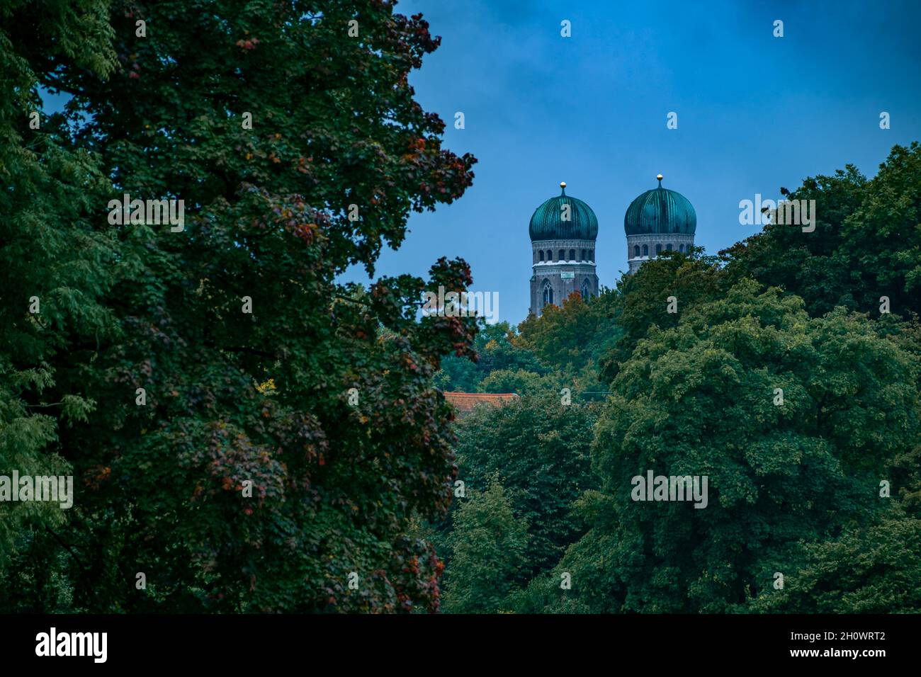 Munich les célèbres tours jumelles de la Etude Frauenkirche sur des arbres de couleur automnale du point de vue du jardin anglais de Munich. Banque D'Images