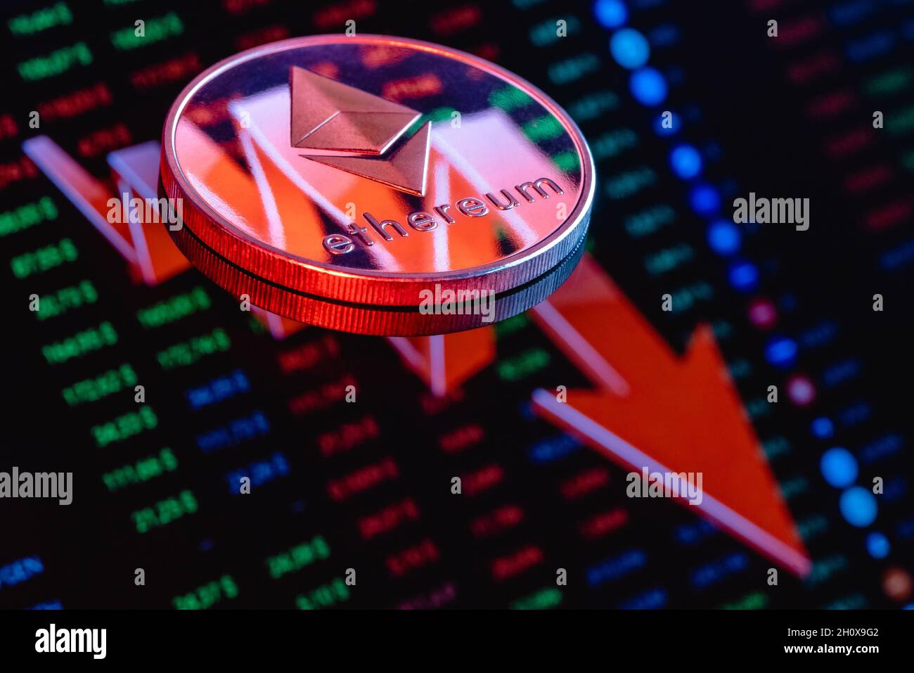 Pièce d'Ethereum sur le fond d'une grande flèche rouge pointant vers le bas.Le concept du taux de chute de l'éthélium. Banque D'Images