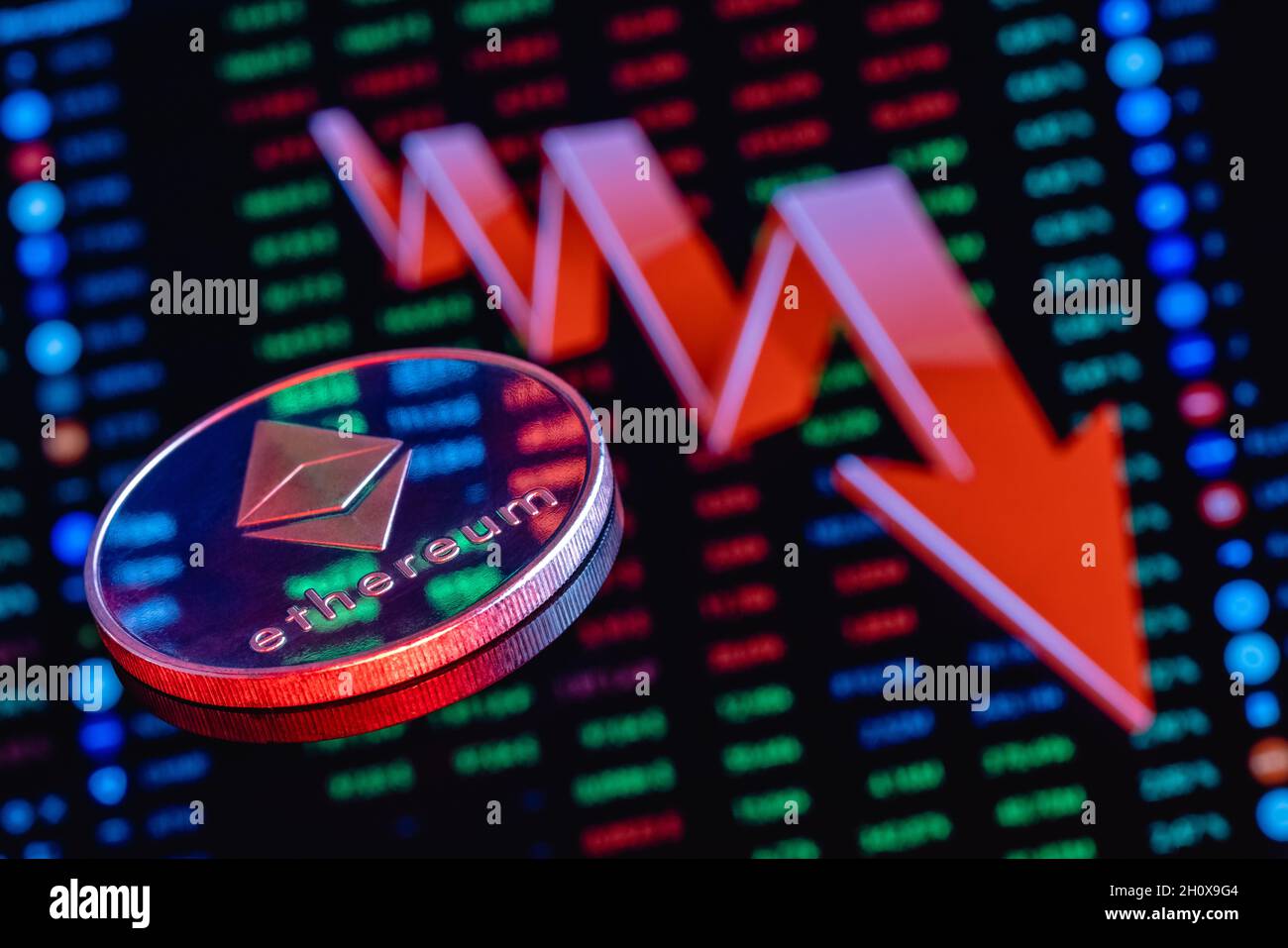 Pièce d'Ethereum sur le fond d'une grande flèche rouge pointant vers le bas.Le concept du taux de chute de l'éthélium. Banque D'Images