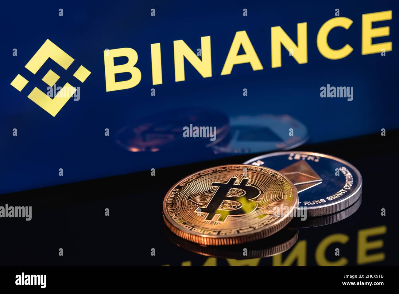 Ethereum coin et Bitcoin sur le fond du logo BINANCE. Banque D'Images