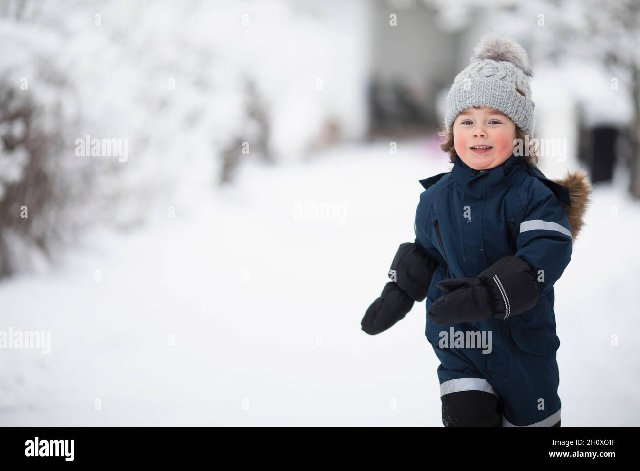 Un garçon souriant en hiver, regardant un appareil photo Banque D'Images