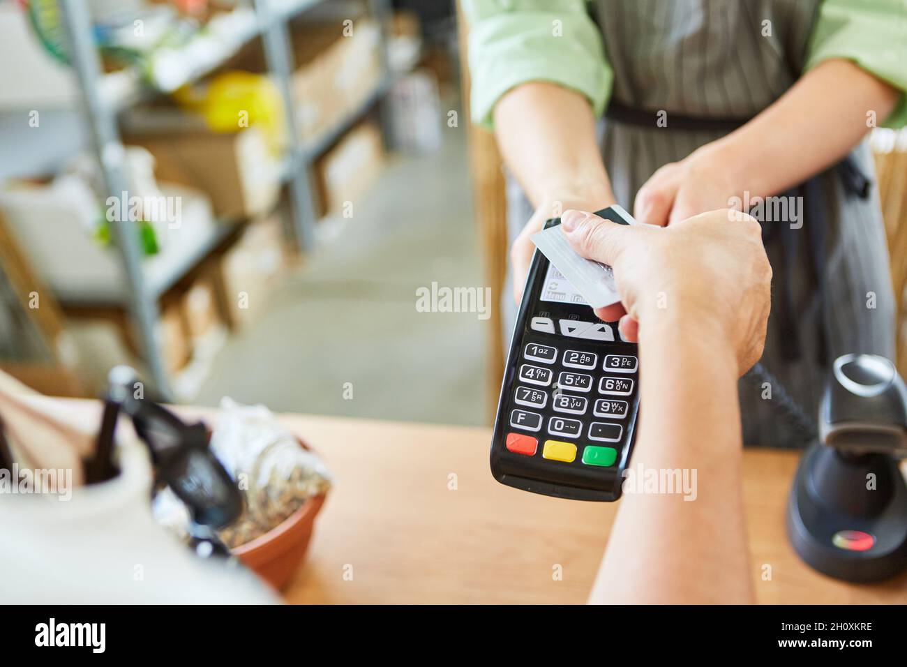 Le client paie avec sa carte de crédit au moment du paiement dans un magasin sans contact via NFC Banque D'Images