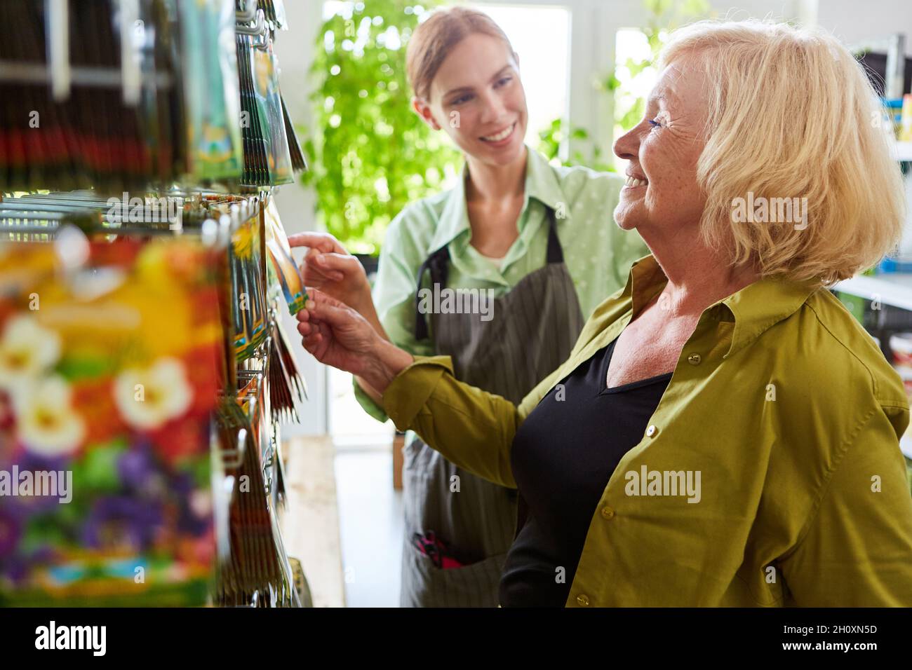 Jeune vendeur conseillant un client dans le centre de jardin ou dans le magasin de matériel Banque D'Images