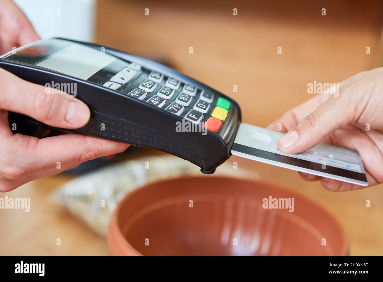 Client et caissier à la caisse pour le paiement mobile avec carte de crédit dans le magasin de matériel Banque D'Images