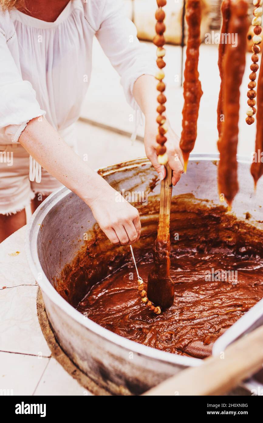 La douceur géorgienne Churchkhela - un sucre traditionnel en forme de saucisse fait en trempant une longue série de noix dans un mélange de farine, de sucre et de badagi - Banque D'Images