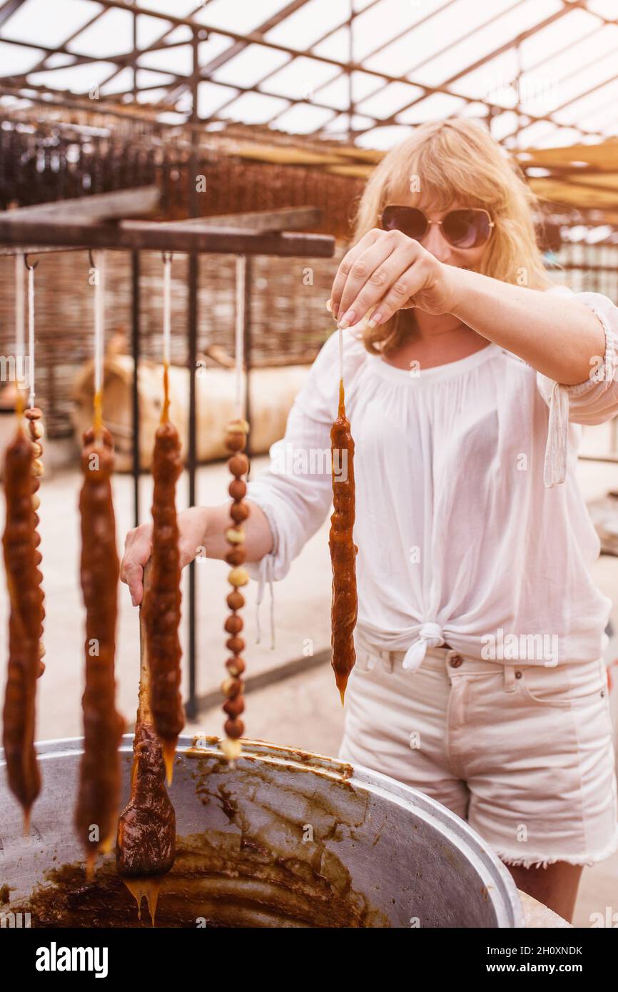 La douceur géorgienne Churchkhela - un sucre traditionnel en forme de saucisse fait en trempant une longue série de noix dans un mélange de farine, de sucre et de badagi - Banque D'Images