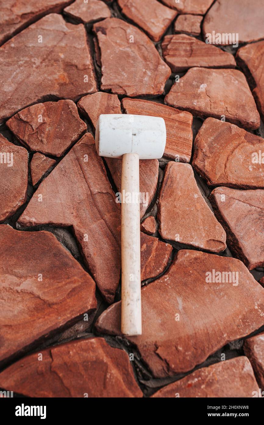 La technologie de pose de pierre naturelle à partir de dalles de pavage - le travail d'une couche de brique pour installer le plancher à l'extérieur Banque D'Images