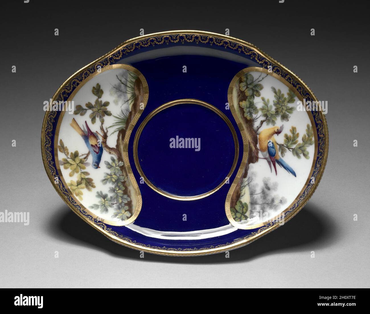 Support pour un Broth Bowl (plateau ovale), 1772.Fabrique de porcelaine de Sèvres (français, est.1756), François-Joseph Aloncle (français).Porcelaine à pâte molle avec émail et décoration dorée; hors tout: 11.2 x 20.2 cm (4 7/16 x 7 15/16 po); partie 2: 3.5 cm (1 3/8 po). Banque D'Images