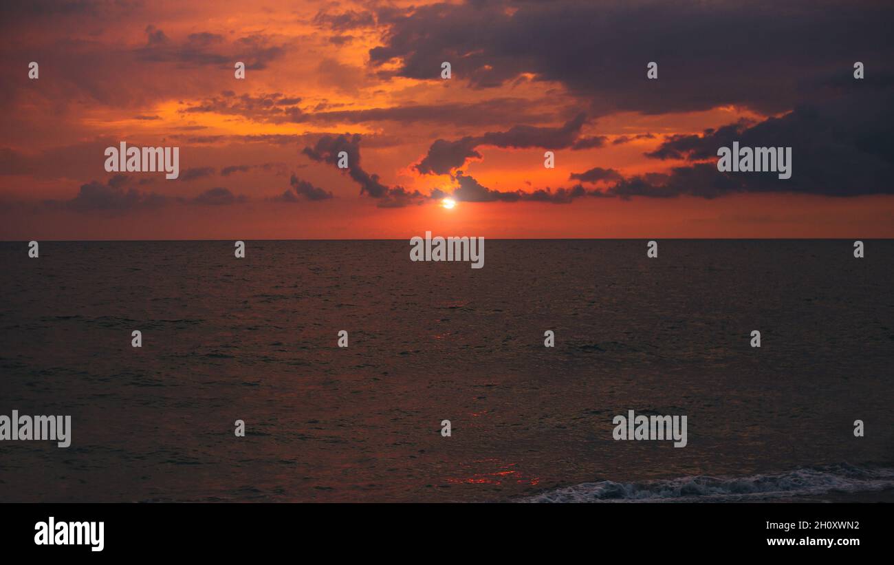 Silence et vide sur l'océan sur fond de soleil rouge vif - coucher de soleil sur la mer Banque D'Images