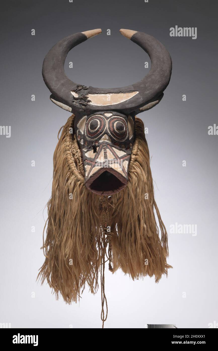 Buffalo Mask, début à mi-1900.Afrique, Afrique de l'Ouest, Burkina Faso, probablement fabricant de style Bwa.Bois, fibres végétales, peinture et fer; total: 69.8 cm (27 1/2 po).Parmi les Bwa, les masques aux traits humains, animaux et fantastiques représentent généralement des esprits protecteurs du Bush.Les cornes et le museau de ce masque l’identifient comme un buffle de brousse.Des danseurs masqués apparaissent pendant la saison sèche à l'occasion d'initiations, de funérailles d'aînés, de journées de marché, de célébrations de récolte et de rituels annuels de renouvellement pour protéger le bien-être de la communauté. Banque D'Images