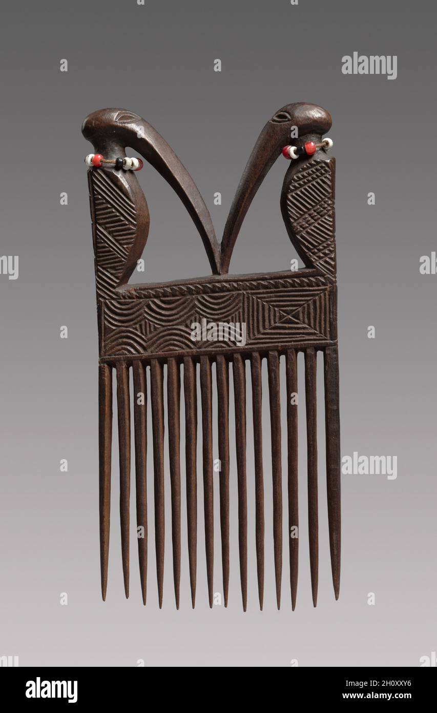 Peigne (cisakulo), mi-fin à fin des années 1800.Afrique, Afrique centrale, Angola ou République démocratique du Congo, Chokwe Carver.Bois, perles de verre et fibres naturelles; total: 13.3 x 8 x 1.4 cm (5 1/4 x 3 1/8 x 9/16 po).Les femmes et les hommes Chokwe ont inséré des peignes et des épingles finement décorés dans leurs cheveux pour signaler leur rang et leur richesse.Ici, comme chez les peuples voisins, les coiffures reflétaient les tendances changeantes à travers le monde et au fil du temps.Le matériau en bois et le dessus sculptural de ce peigne en ont fait une valeur supérieure à celle des exemples simples faits de métal ou de canne.Ses dents larges étaient pratiques, fixant les éléments d'une coiffure dans Banque D'Images