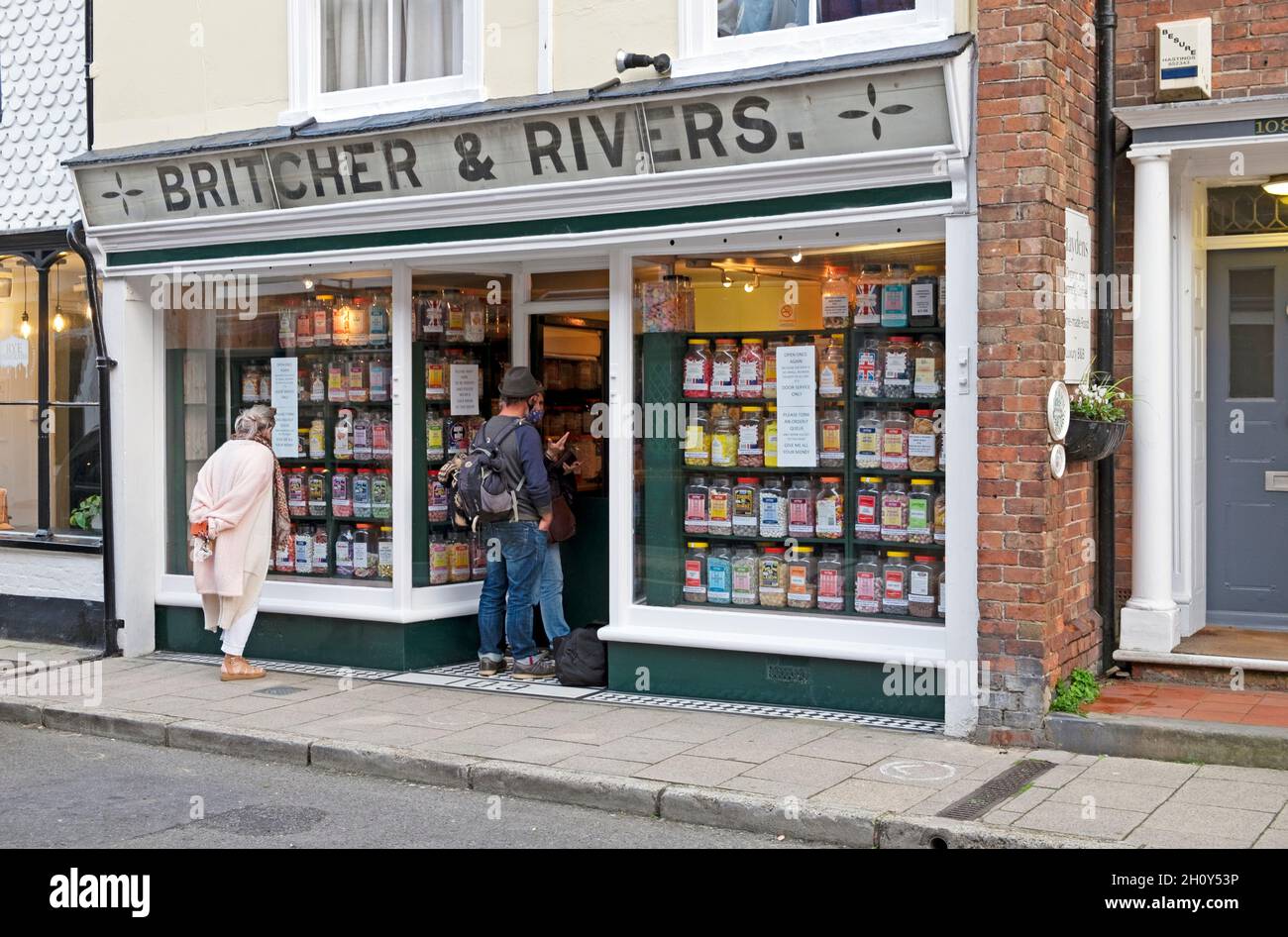 Personnes femme debout dans la rue regardant dans la fenêtre de magasin Britcher & Rivers Sweet store window Rye East Sussex Angleterre Grande-Bretagne KATHY DEWITT Banque D'Images